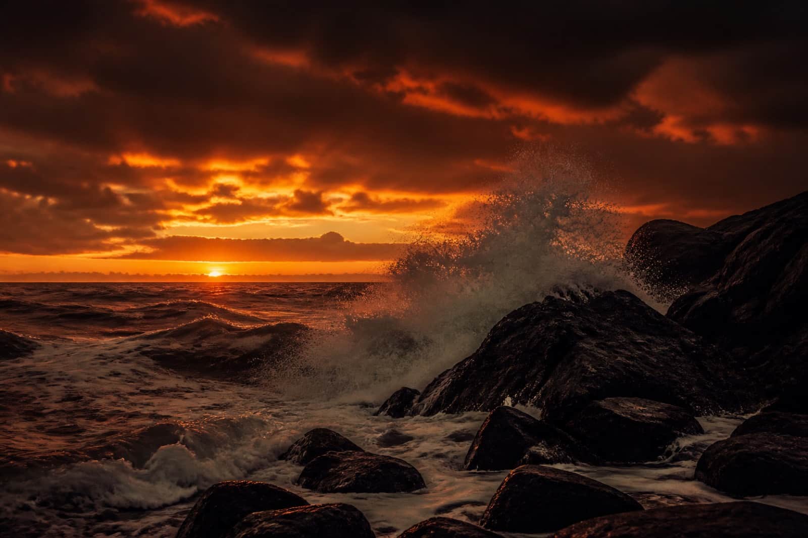 Stormy sea at sunset with waves crashing on rocks
