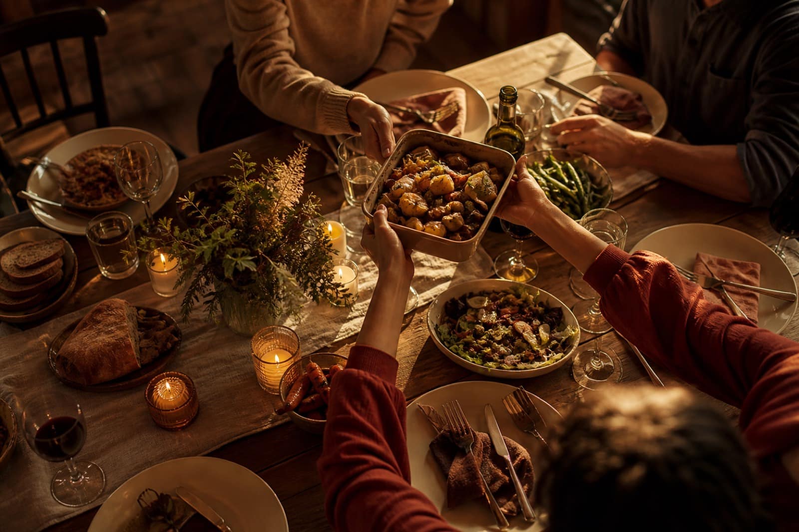 Family dinner table with hands passing dishes